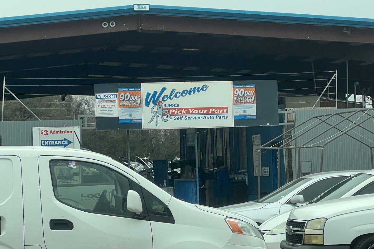 Pick Your Part - Houston Northville: Covered entrance to a self-service auto parts yard with a welcome sign, admission sign and cars parked in front