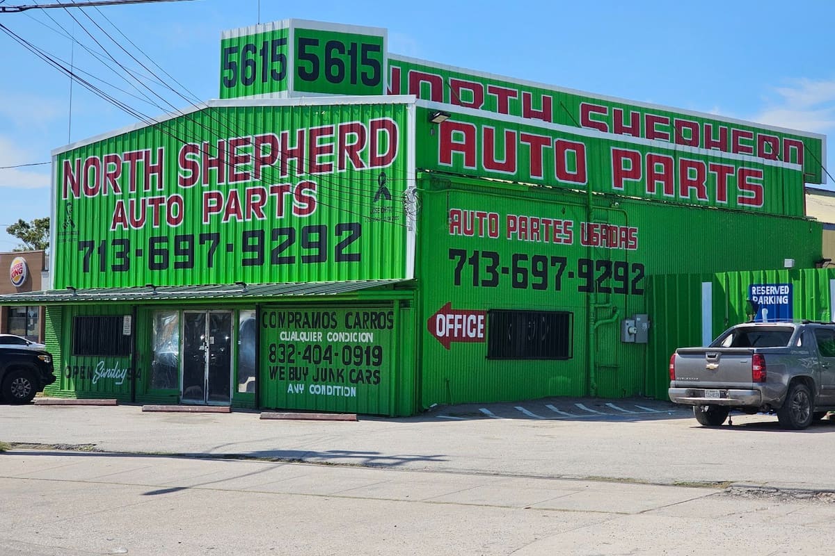 North Shepherd Auto Parts: Green metal auto parts building with large red lettering, street number 5615 on the roof, and a pickup truck parked nearby
