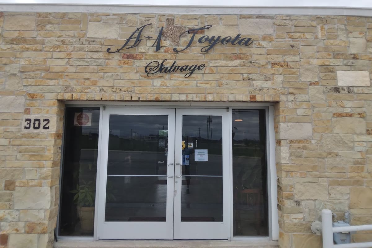 A-1 Toyota Salvage: Stone-front building with double glass doors, address number 302 and a cursive sign above the entrance