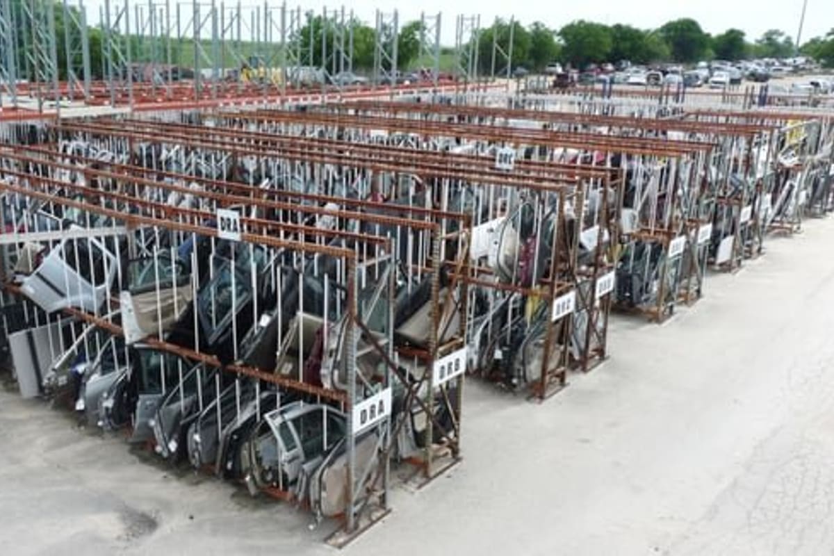 A1 Parts Mart: Aerial view of a salvage yard with long racks of used car doors and parts, and vehicles parked in the background