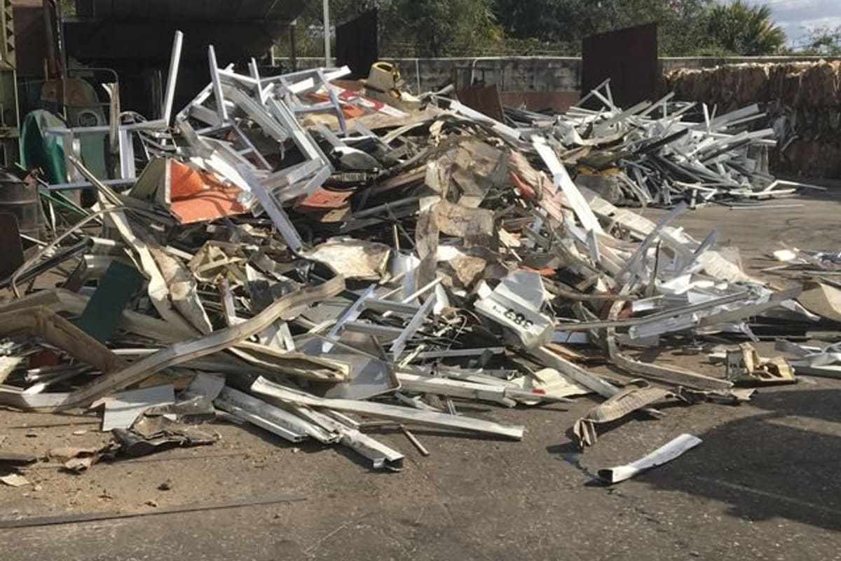 Inter-County Recycling: Pile of scrap aluminum and metal on a paved recycling yard with sheds and baled material behind