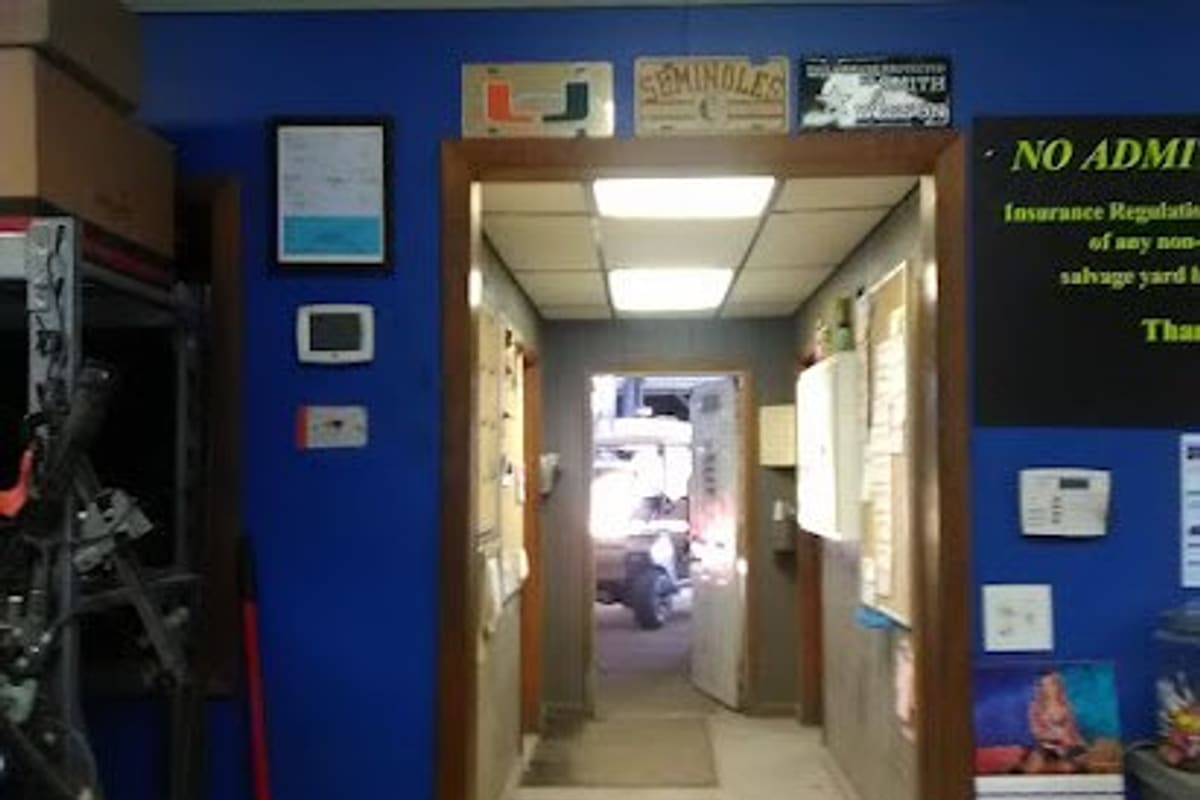 American Auto & Truck Salvage: Interior office wall with a doorway opening to a hallway and a posted notice about salvage yard rules