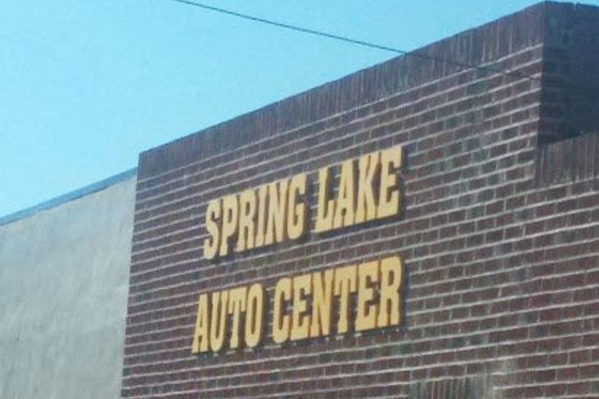 Spring Lake Auto Center: Brick building with large yellow lettering on the wall reading Spring Lake Auto Center under a clear blue sky