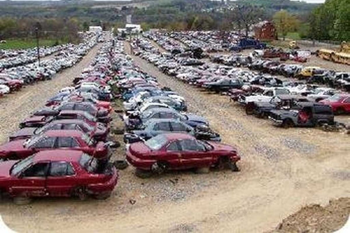 Mykawa Auto Parts: Wide view of a salvage yard with long rows of wrecked cars on a gravel lot and hills in the distance