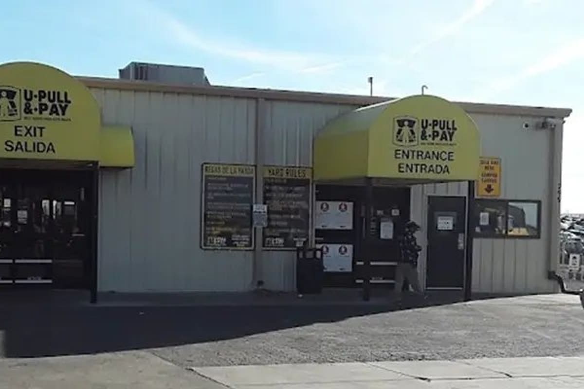 U-Pull-&-Pay Denver: Metal building with yellow awnings marking separate entrance and exit doors, with posted yard rules between them