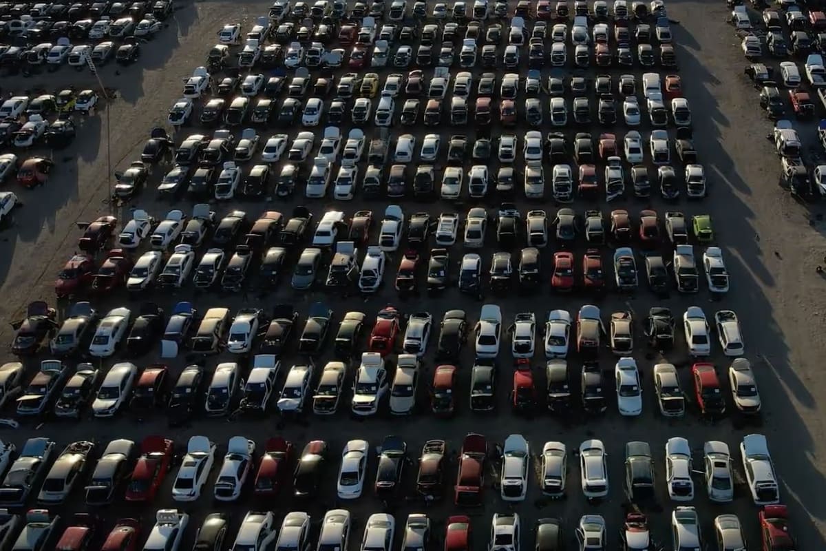 Lubbock Wrench A Part: Aerial view of a large salvage yard with many cars parked in long rows on a dirt lot
