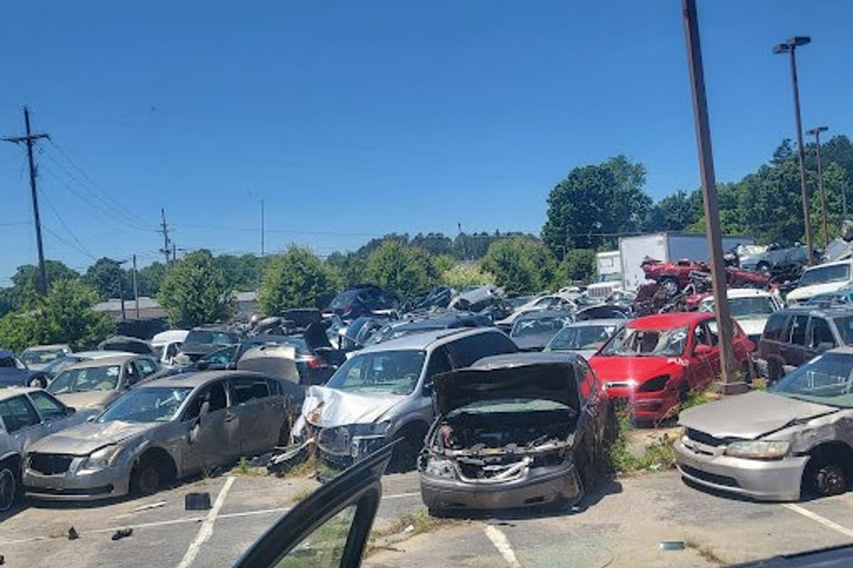 Mike's Auto Salvage: Crowded salvage lot with rows of wrecked cars under a clear blue sky