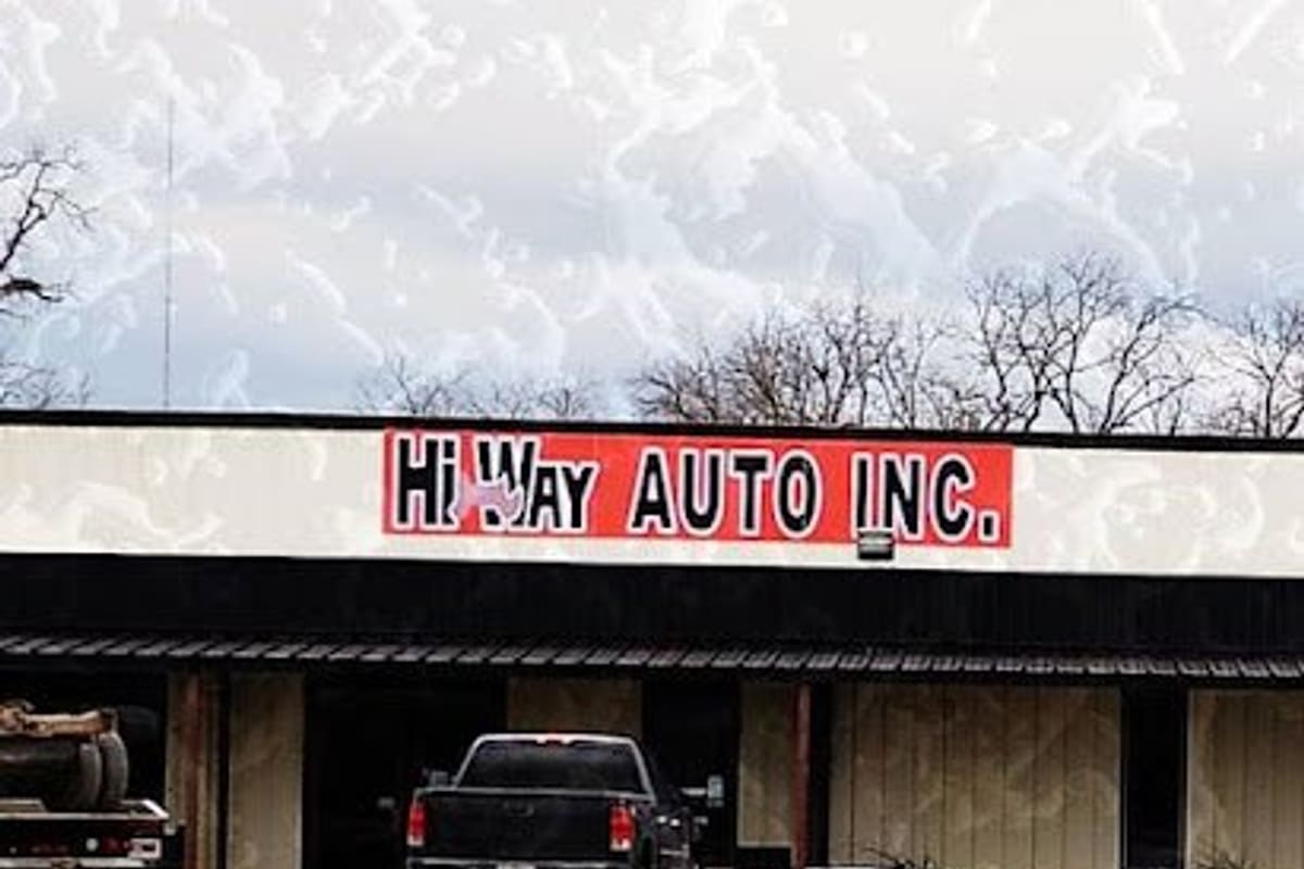 Hi Way Auto Parts: Single-story storefront with a red sign reading Hi Way Auto Inc., a black pickup parked in front, and an open paved lot