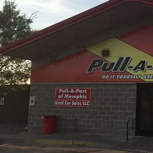 Pull-A-Part Memphis: Brick storefront with red and yellow facade, large Pull-A-Part sign, glass entrance doors and street number 2955