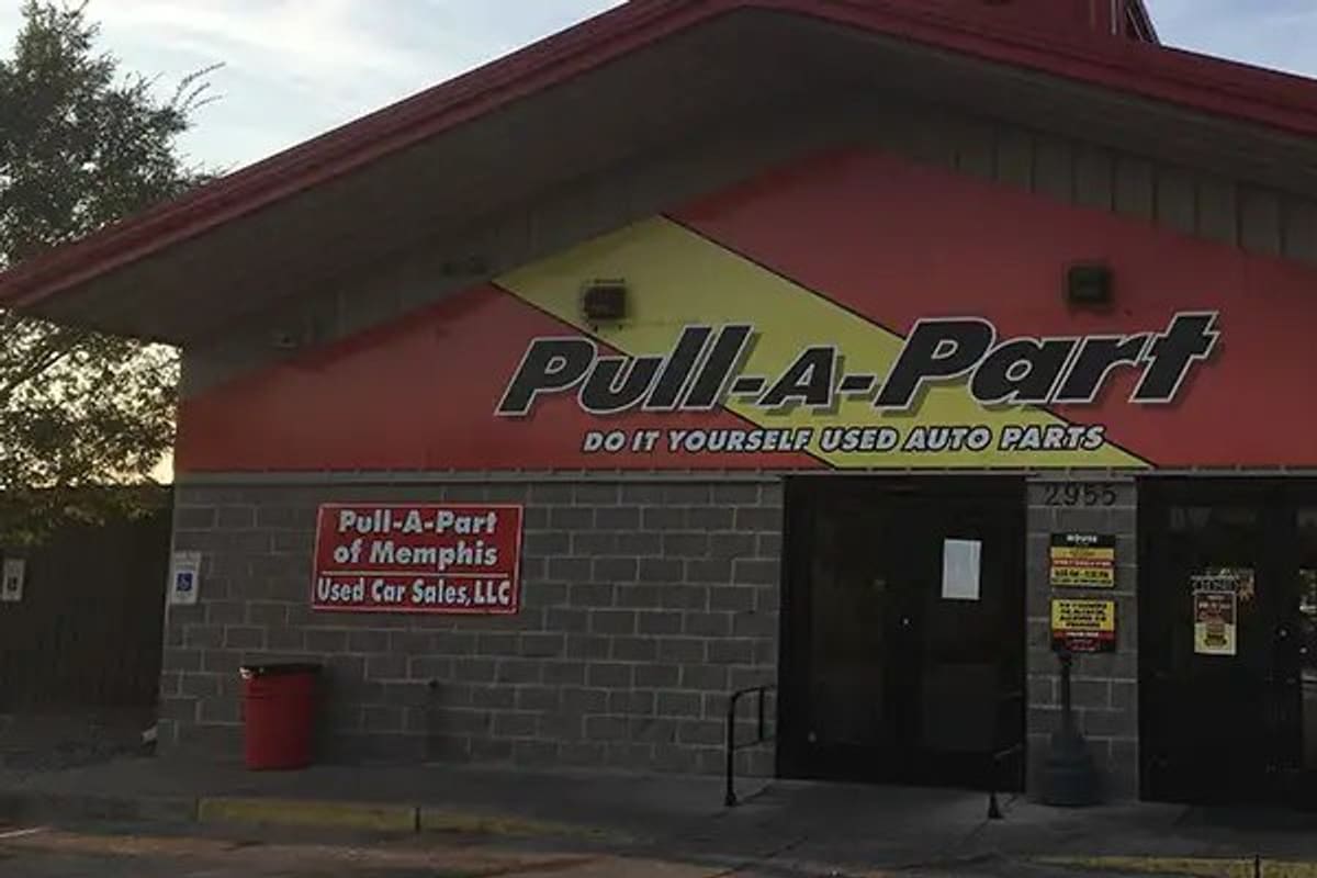 Pull-A-Part Memphis: Brick storefront with red and yellow facade, large Pull-A-Part sign, glass entrance doors and street number 2955