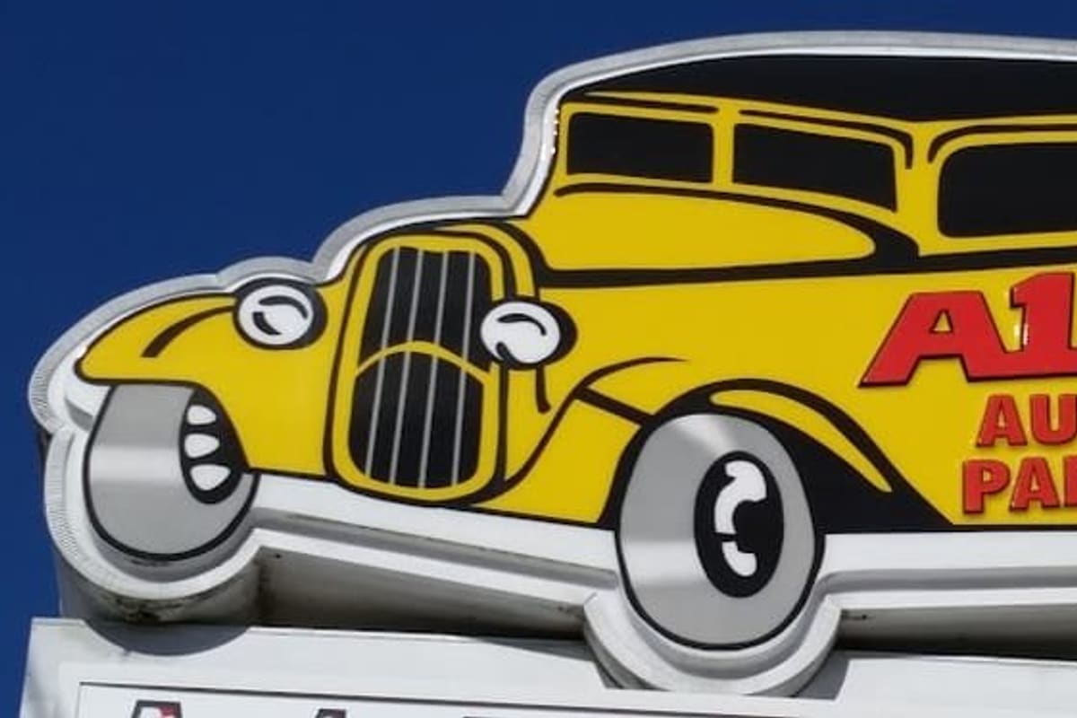 A1A Auto Parts: Yellow vintage car-shaped sign reading A1A Auto Parts against a clear blue sky
