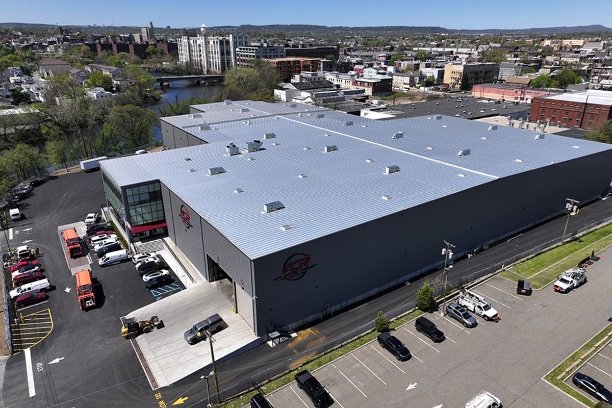 Atlantic Coast Recycling: Aerial view of a large gray industrial building with a metal roof, a glass office section and parking lots around it