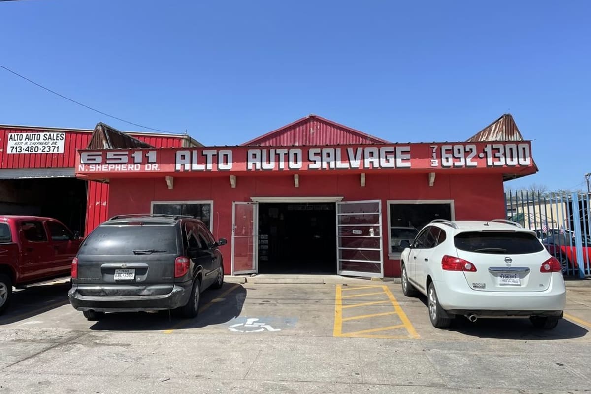 Contla: Red storefront with a large painted sign and open entrance, with cars parked in front under a clear blue sky