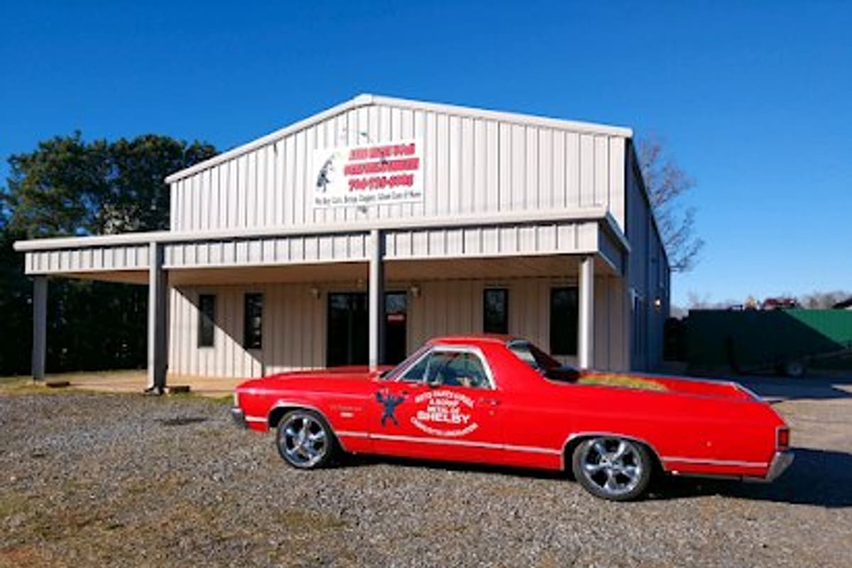 Auto Parts U Pull - Lincolnton: Metal shop building with a covered front porch and a red sign, a red El Camino parked on the gravel lot in front