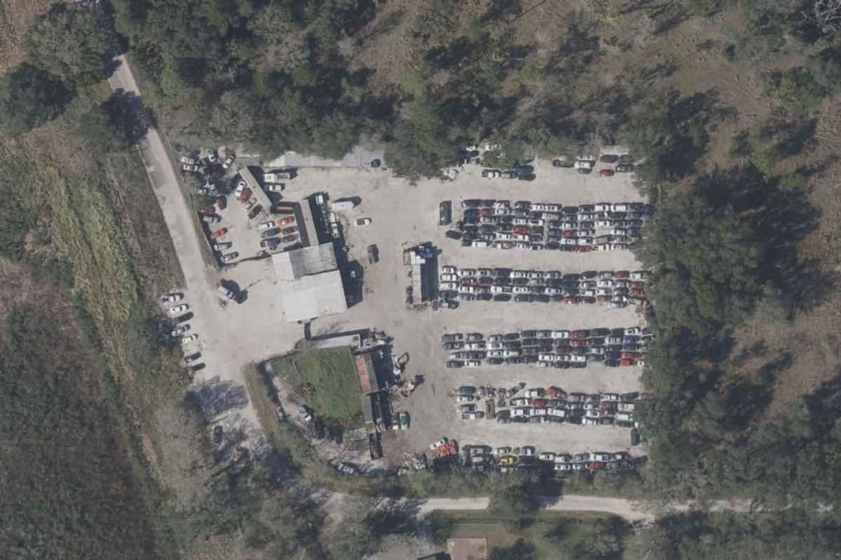 Stepp's Auto and Truck Salvage: Aerial view of a large salvage lot with rows of parked vehicles and buildings surrounded by trees