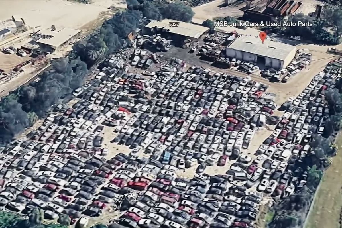 MSB Used Auto Parts: Aerial view of a large salvage yard with dense rows of cars and a metal warehouse building near the top