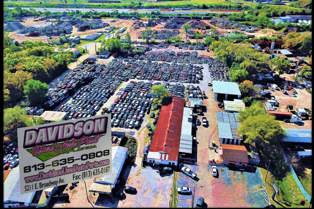 Davidson Used Auto Parts: Aerial view of a large salvage yard with rows of cars, metal-roofed buildings and trees