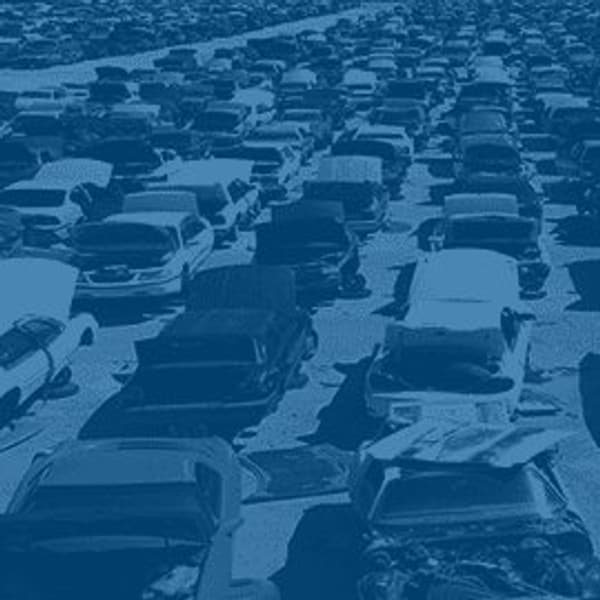 Pick Your Part - Bradenton: Aerial view of rows of junked cars packed closely together across a large salvage yard, tinted blue