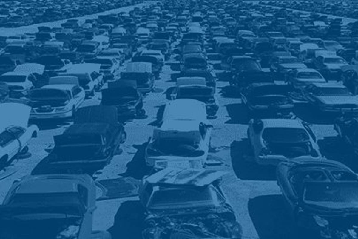 Pick Your Part - Bradenton: Aerial view of rows of junked cars packed closely together across a large salvage yard, tinted blue