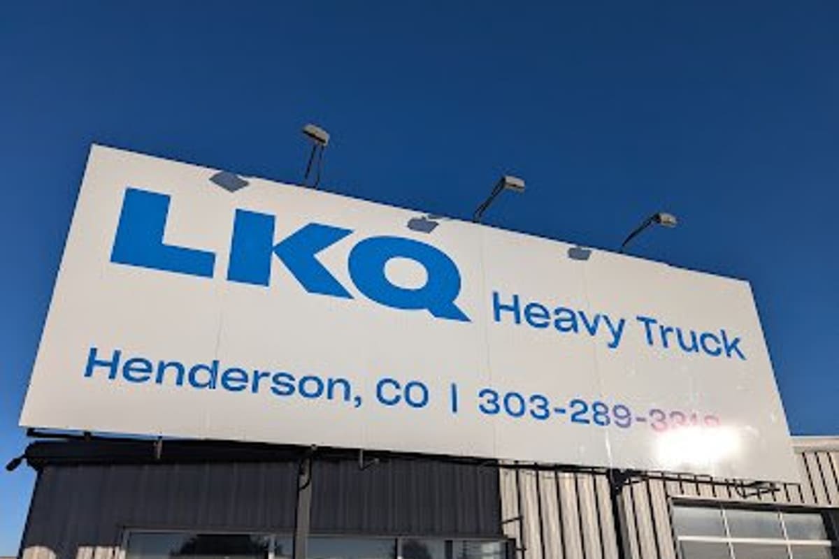 LKQ Heavy Truck - Henderson: Large white rooftop sign with blue lettering on a metal-sided building under a clear blue sky