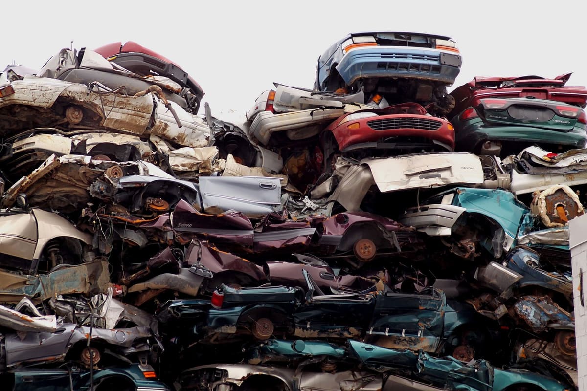 Western Auto Recycling: Tall stack of crushed and flattened cars piled high at an auto salvage yard
