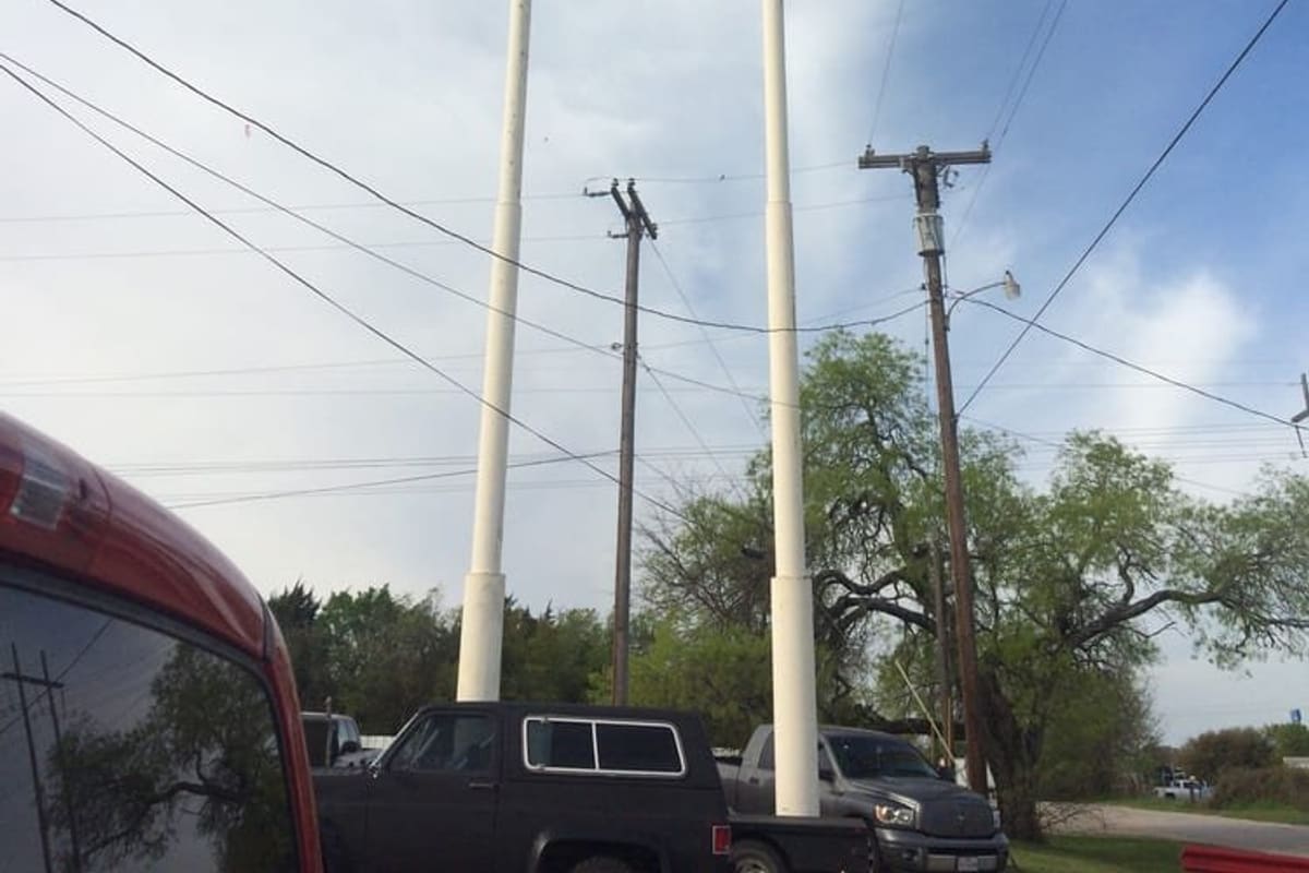 Doggett Auto Parts: Tall roadside sign reading Doggett's Recycled Auto & Truck Parts on two white poles above trees and parked trucks