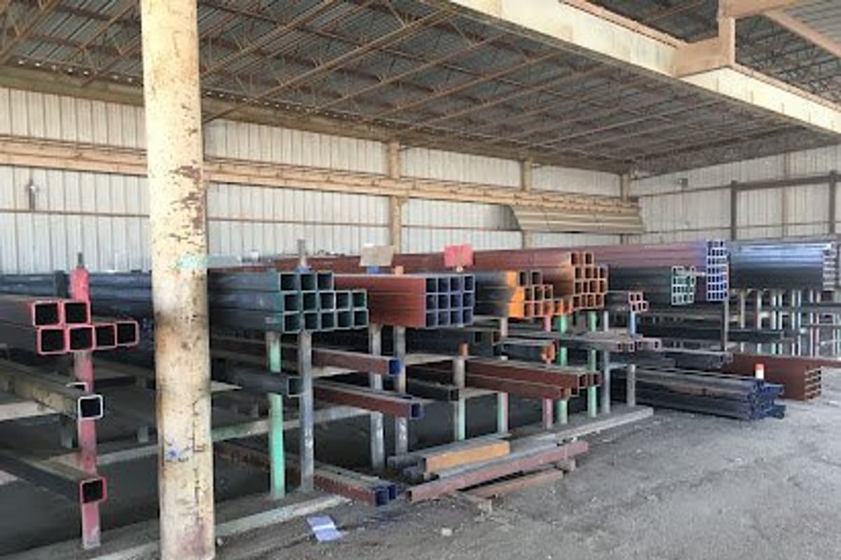 River City Steel & Recycling: Covered storage area with racks of square and rectangular steel tubing stacked under a metal roof