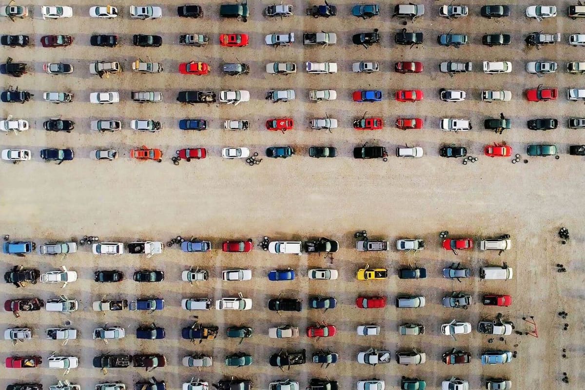 U-Pull-&-Pay Colorado Springs: Aerial view of a self-service salvage yard with long rows of parked cars on dirt ground