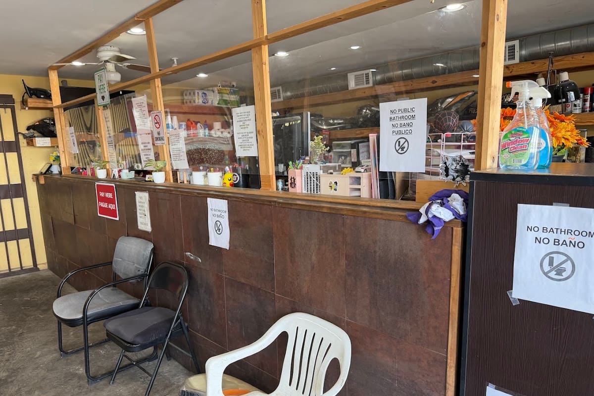 USA Metals: Interior of a small service office with a wooden counter, glass partition, waiting chairs and posted notices