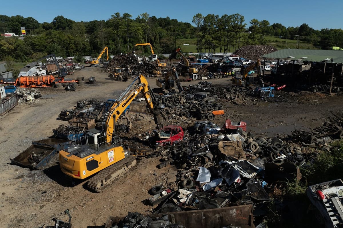 Tennessee Auto Salvage & Recycling: Aerial view of a salvage yard with excavators working among piles of scrap metal, tires and vehicles