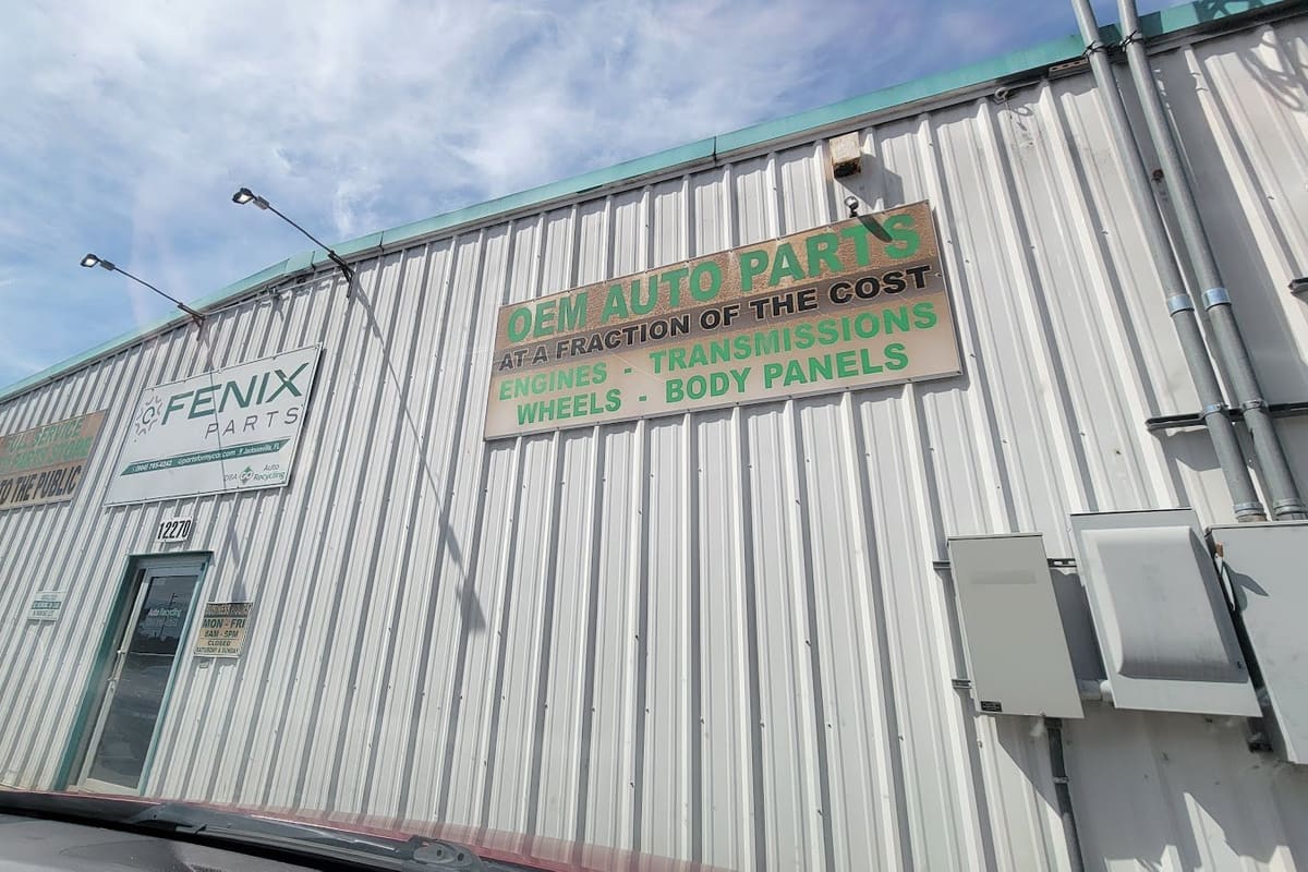 Fenix Parts - Jacksonville: Corrugated metal warehouse building with a large OEM auto parts sign, a smaller sign above the door, and the street number 12270