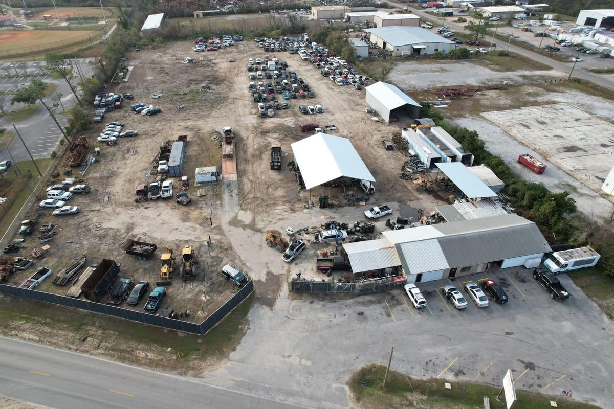 Van Horn Auto Salvage & Scrap Metal: Aerial view of a salvage yard with rows of vehicles, covered work areas, and a parking lot beside the main building
